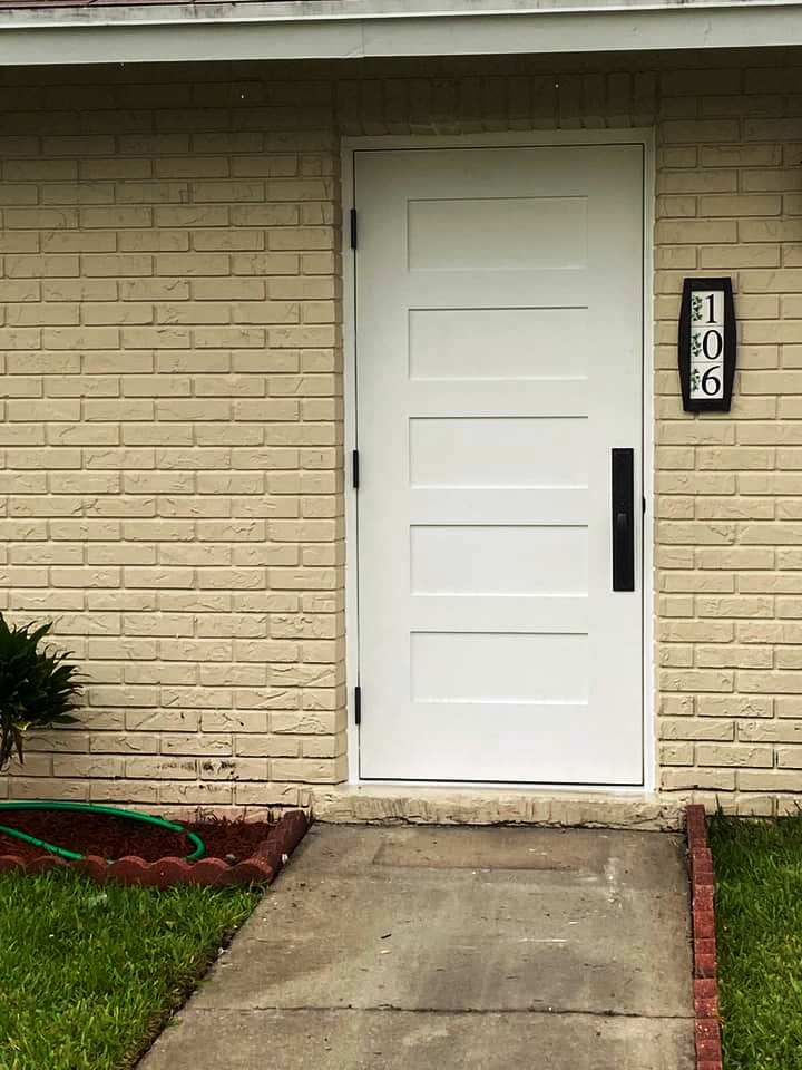 The front door of a brick house with a white door