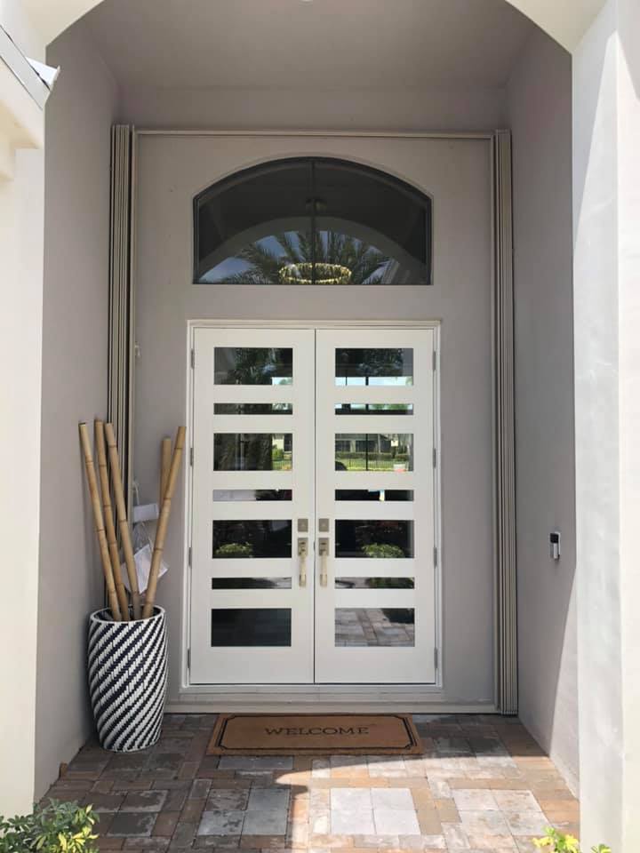 The front door of a house with a welcome mat in front of it.