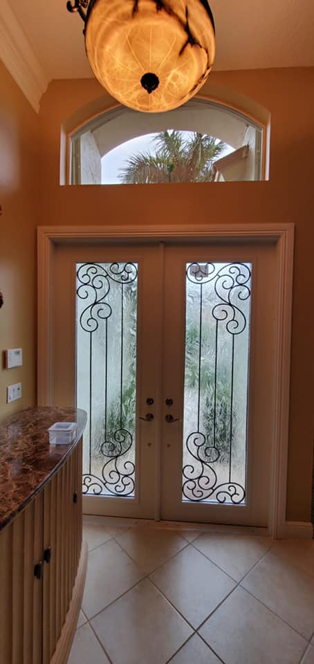 There is a chandelier hanging from the ceiling above the door.