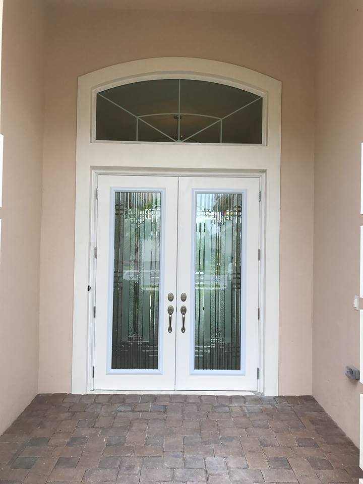 The front door of a house has a stained glass window above it.