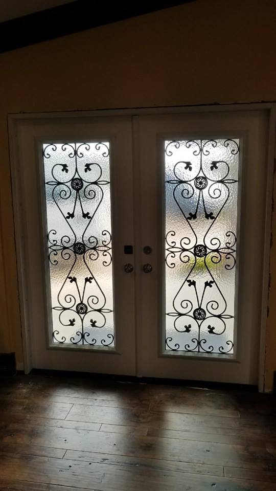 A pair of double doors with stained glass in a room.