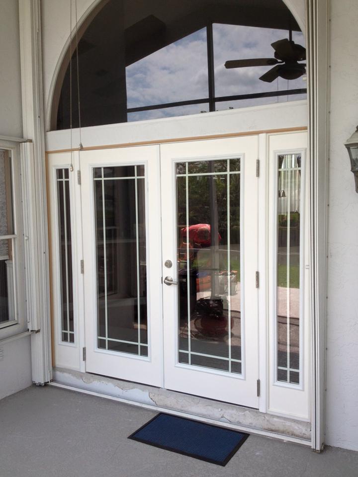 A white door with a ceiling fan above it
