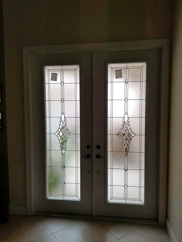 A pair of stained glass doors in a hallway.