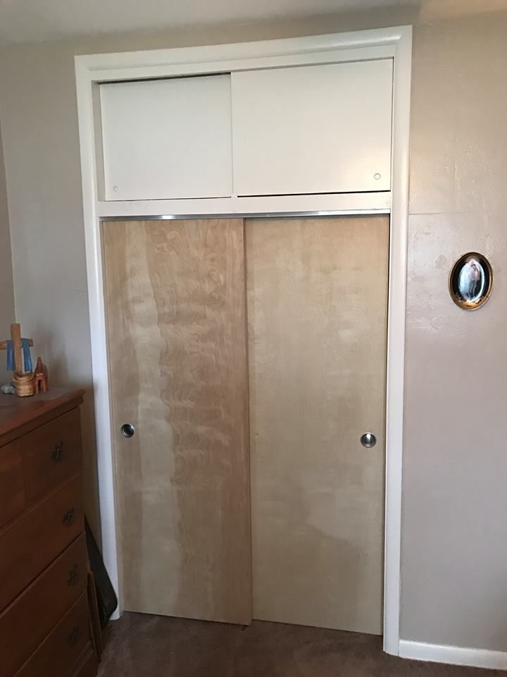 A closet with sliding doors and a picture on the wall.
