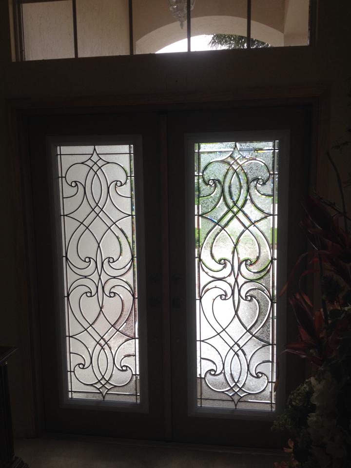 A pair of stained glass doors with a wrought iron frame