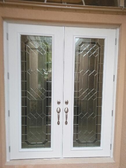 A pair of white double doors with stained glass windows.