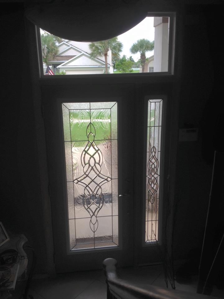 A door with a stained glass window in a dark room.