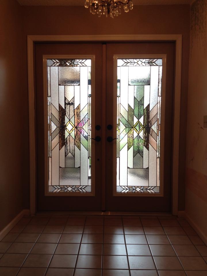 A hallway with stained glass doors and a chandelier