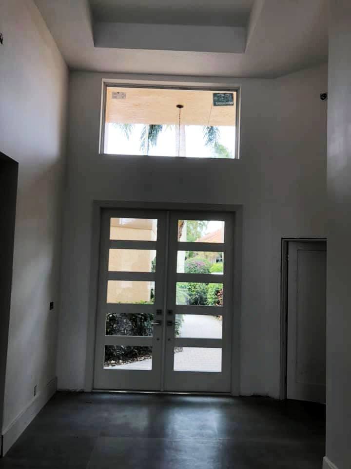 An empty room with two doors and a large window.