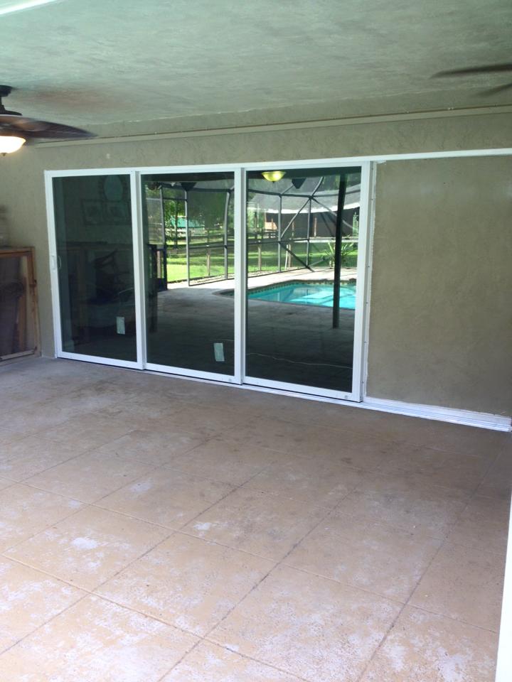 A patio with sliding glass doors leading to a pool