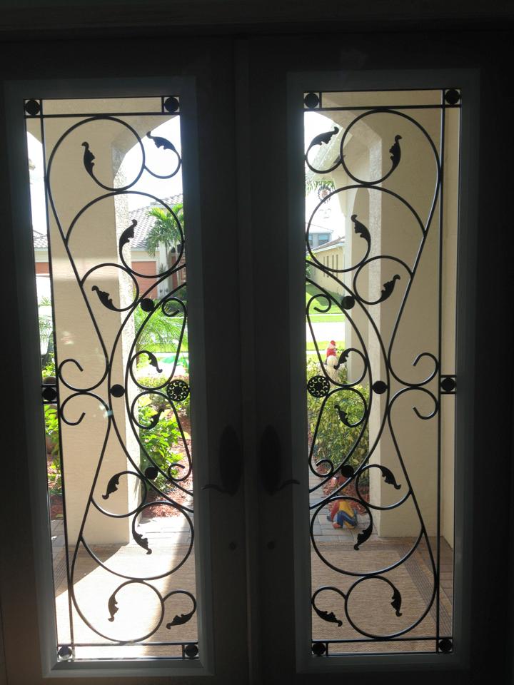 A pair of doors with a wrought iron design on them