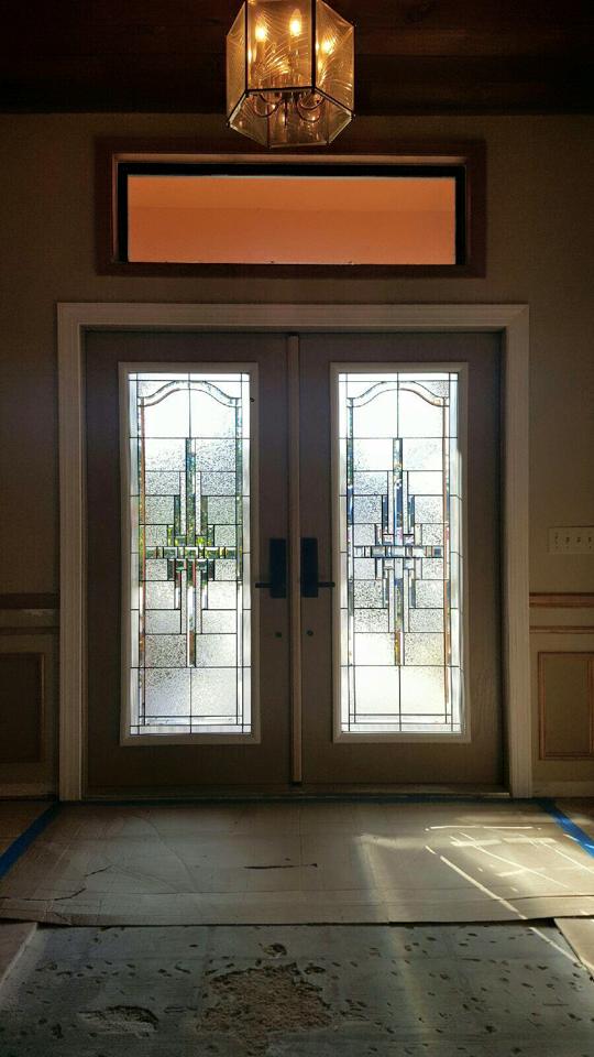 There is a chandelier hanging from the ceiling above the door.