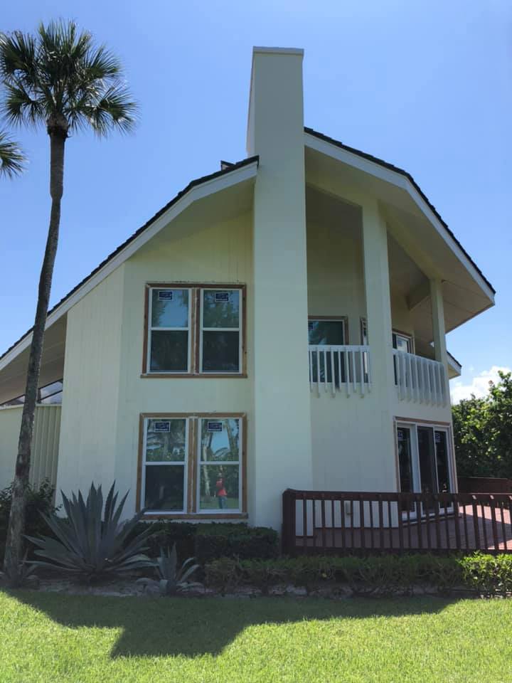 A large white house with a palm tree in front of it