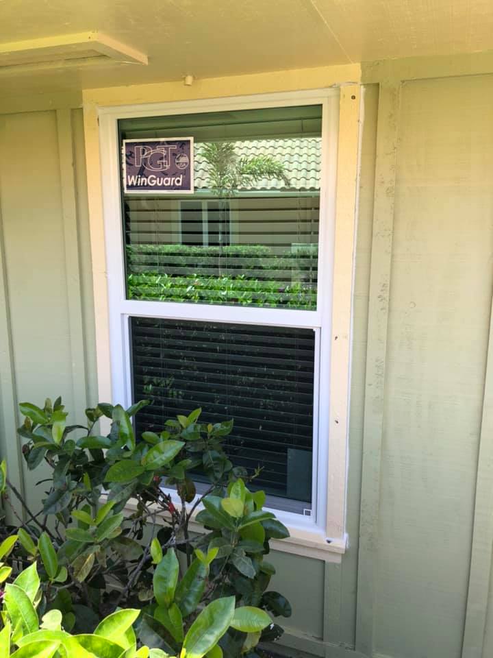 A window on the side of a house with a sign on it.