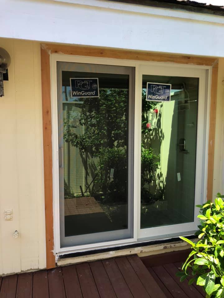 A sliding glass door is sitting on a wooden deck.