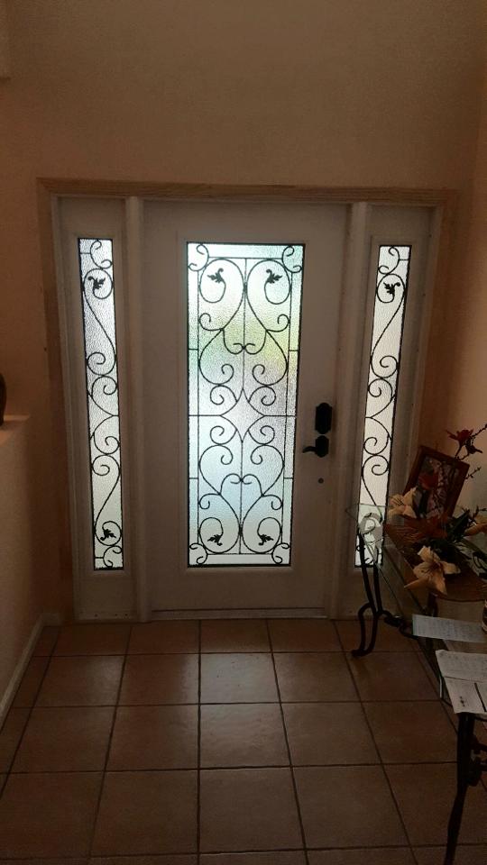 A white door with stained glass windows in a hallway.