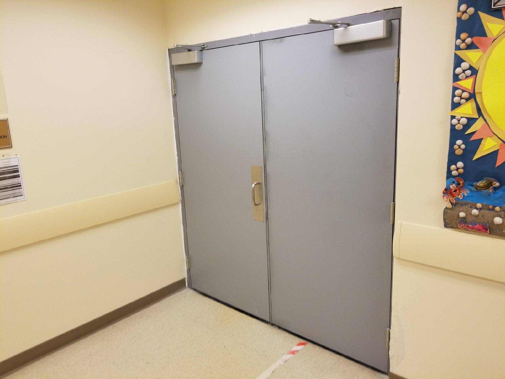 There is a picture of a sun on the wall behind the door.