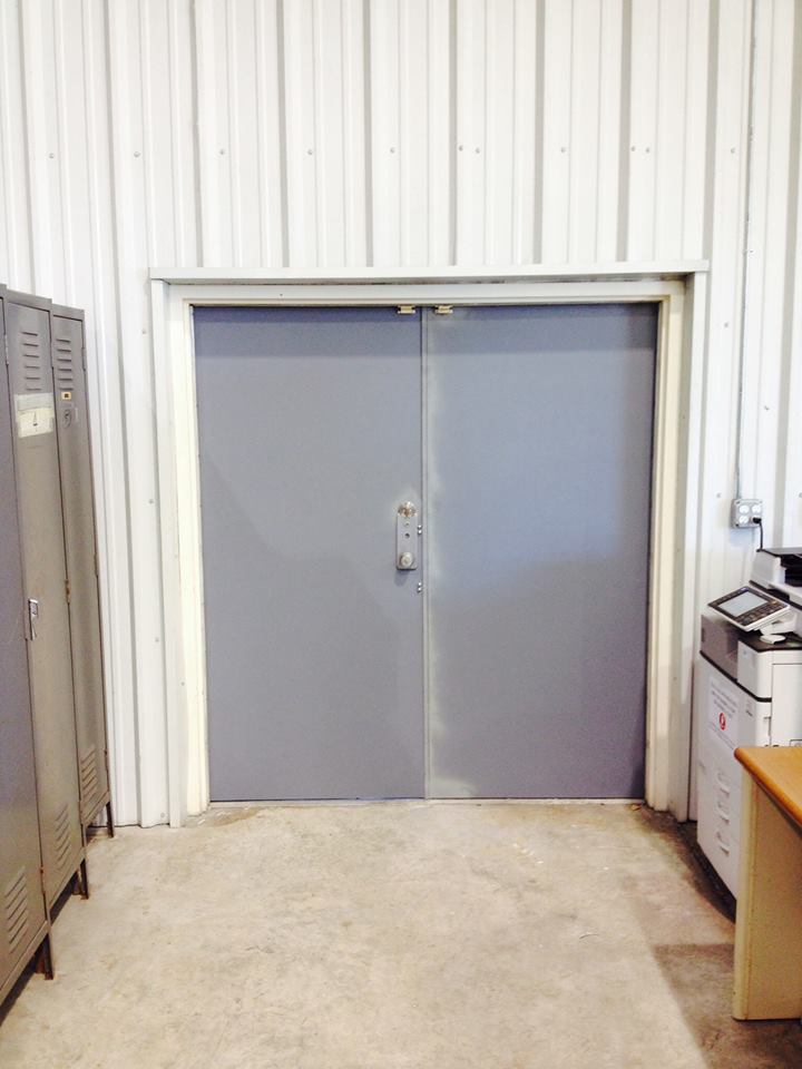 A room with a gray door and lockers in it.