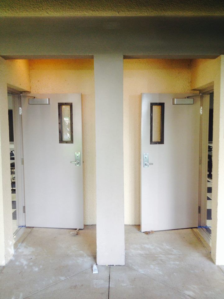 A room with two white doors between two pillars