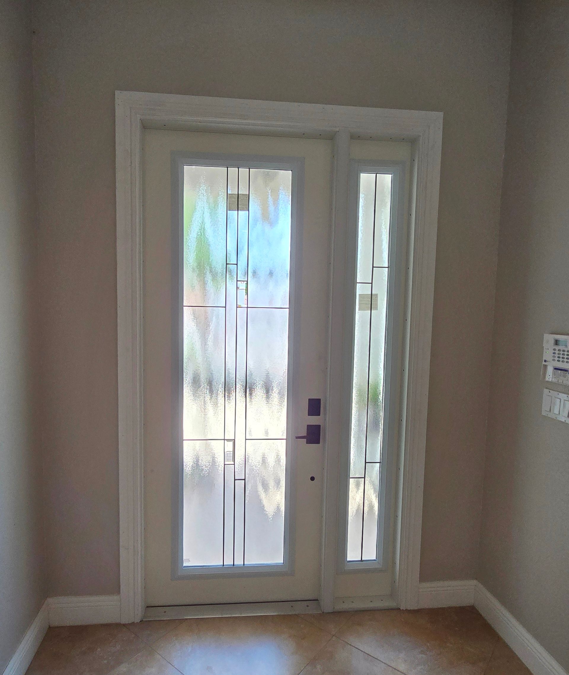 An empty room with a door and a window.