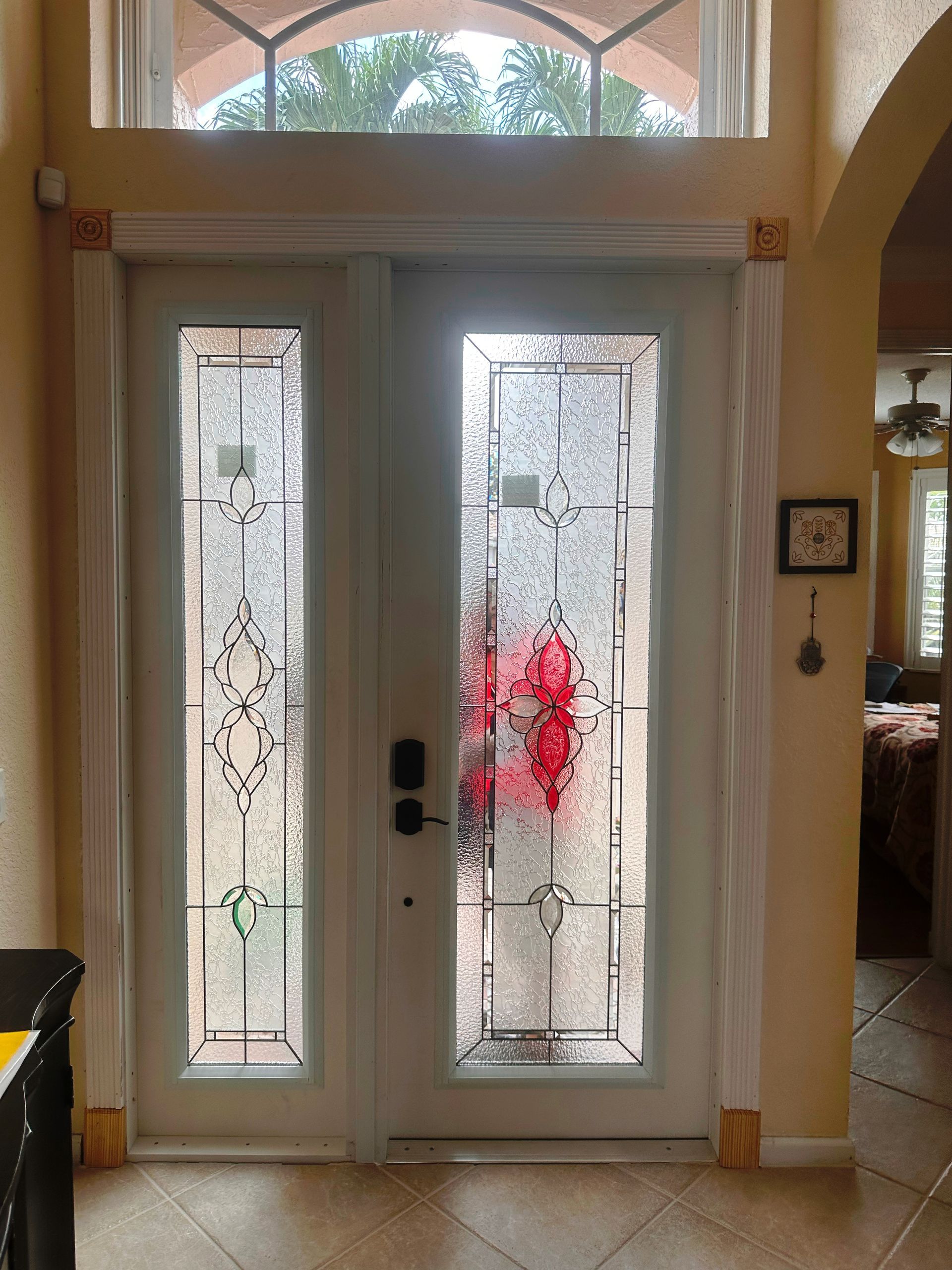 A white door with stained glass windows in a living room.
