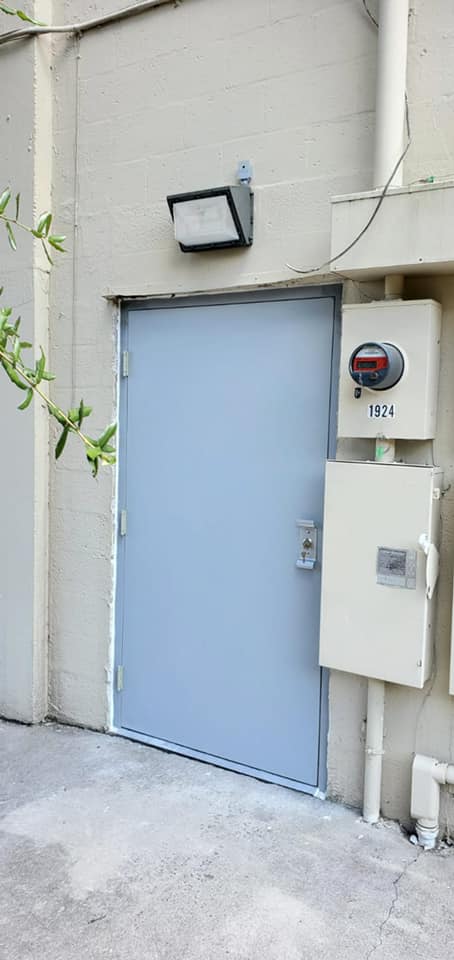 A blue door is sitting on the side of a building.