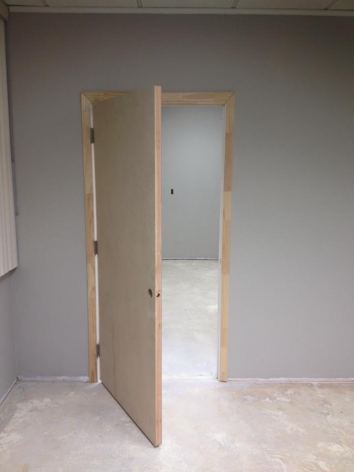 An empty room with a door open and a window.