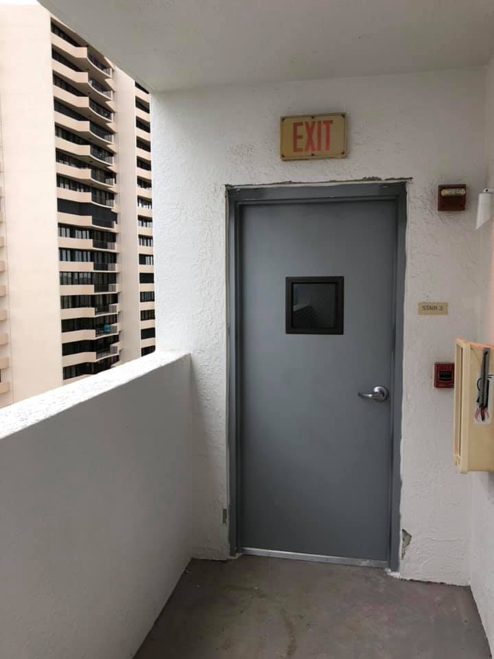 A gray door with an exit sign above it