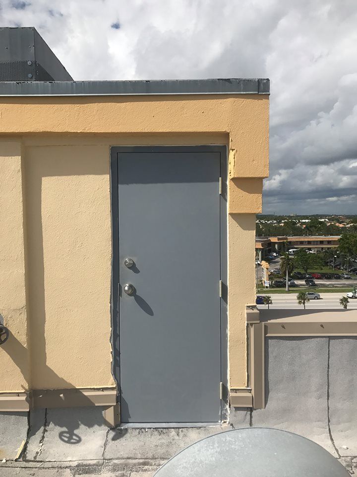 A gray door is on the side of a building.