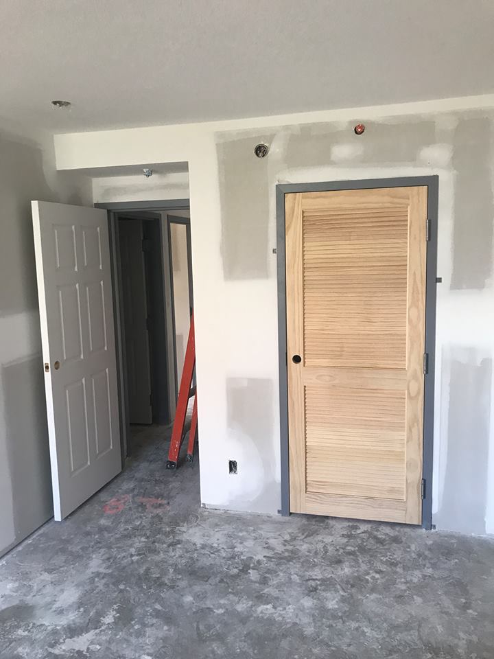 A room with two doors and a ladder in it.