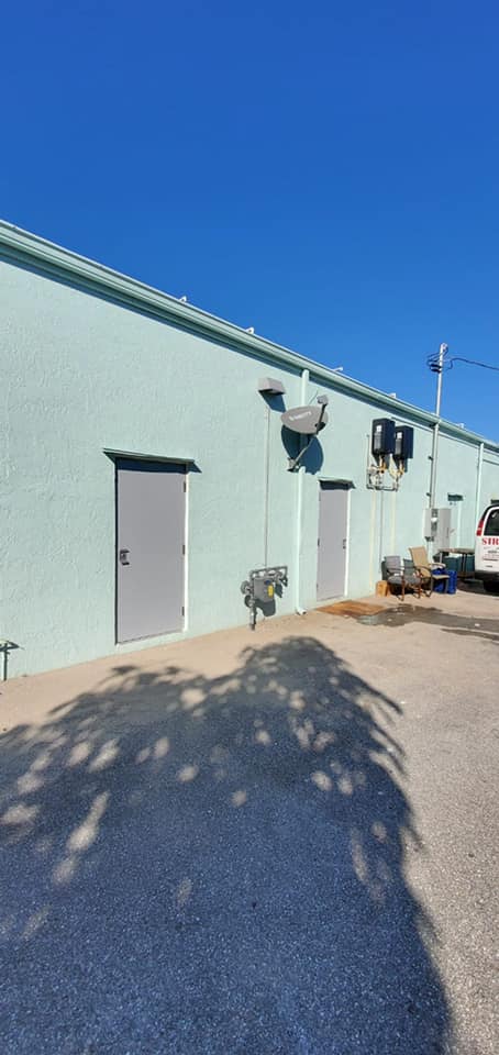 A building with a lot of doors and a car parked in front of it.