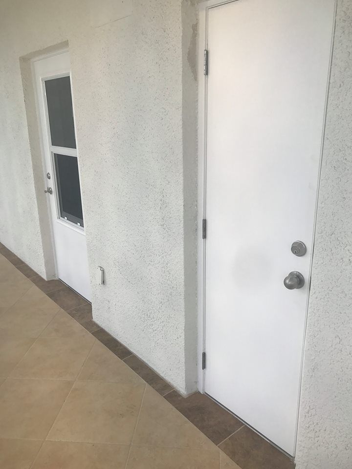 A hallway with two white doors and a window.