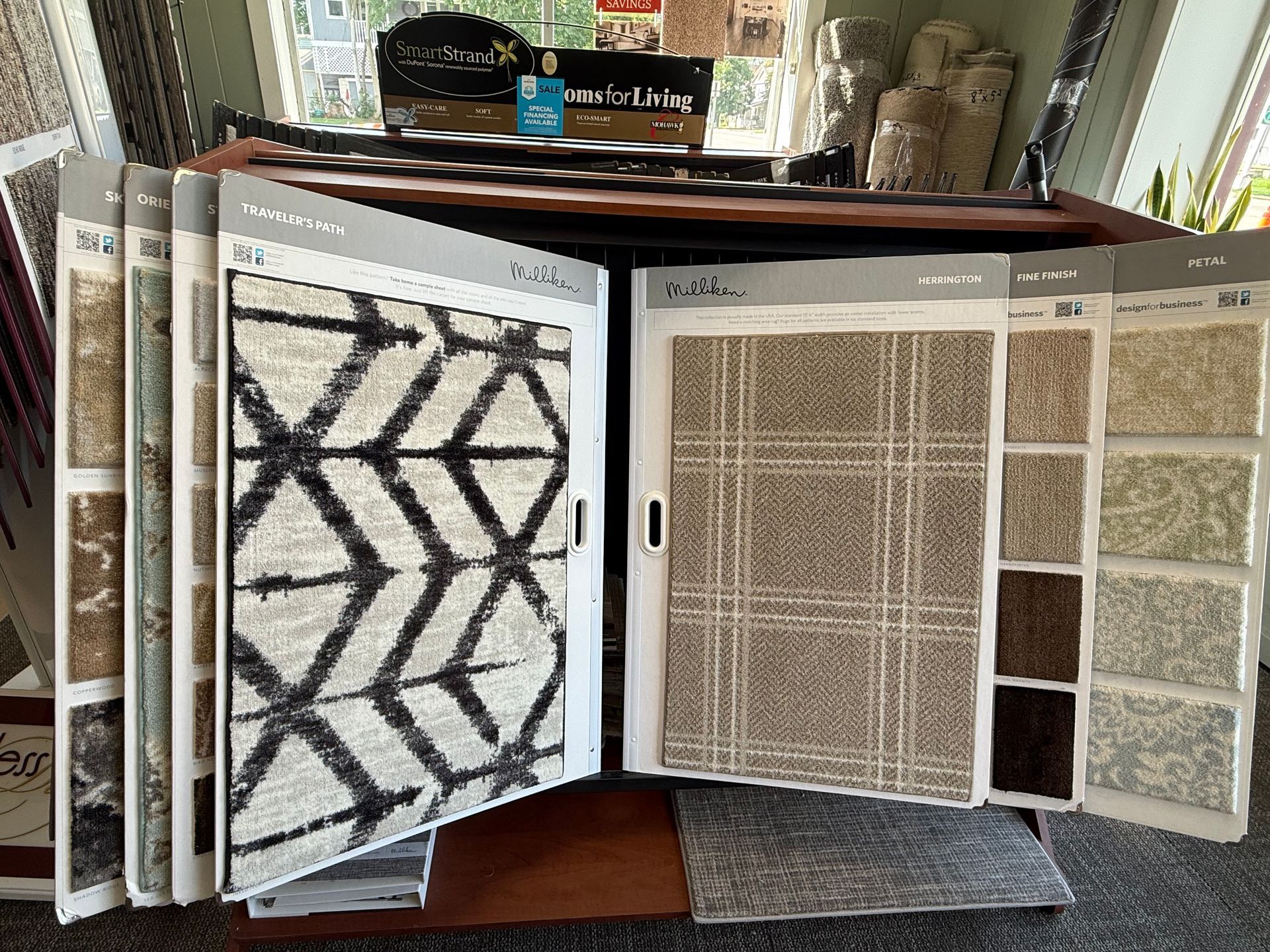 Display of multiple carpet and rug samples on stands in a showroom