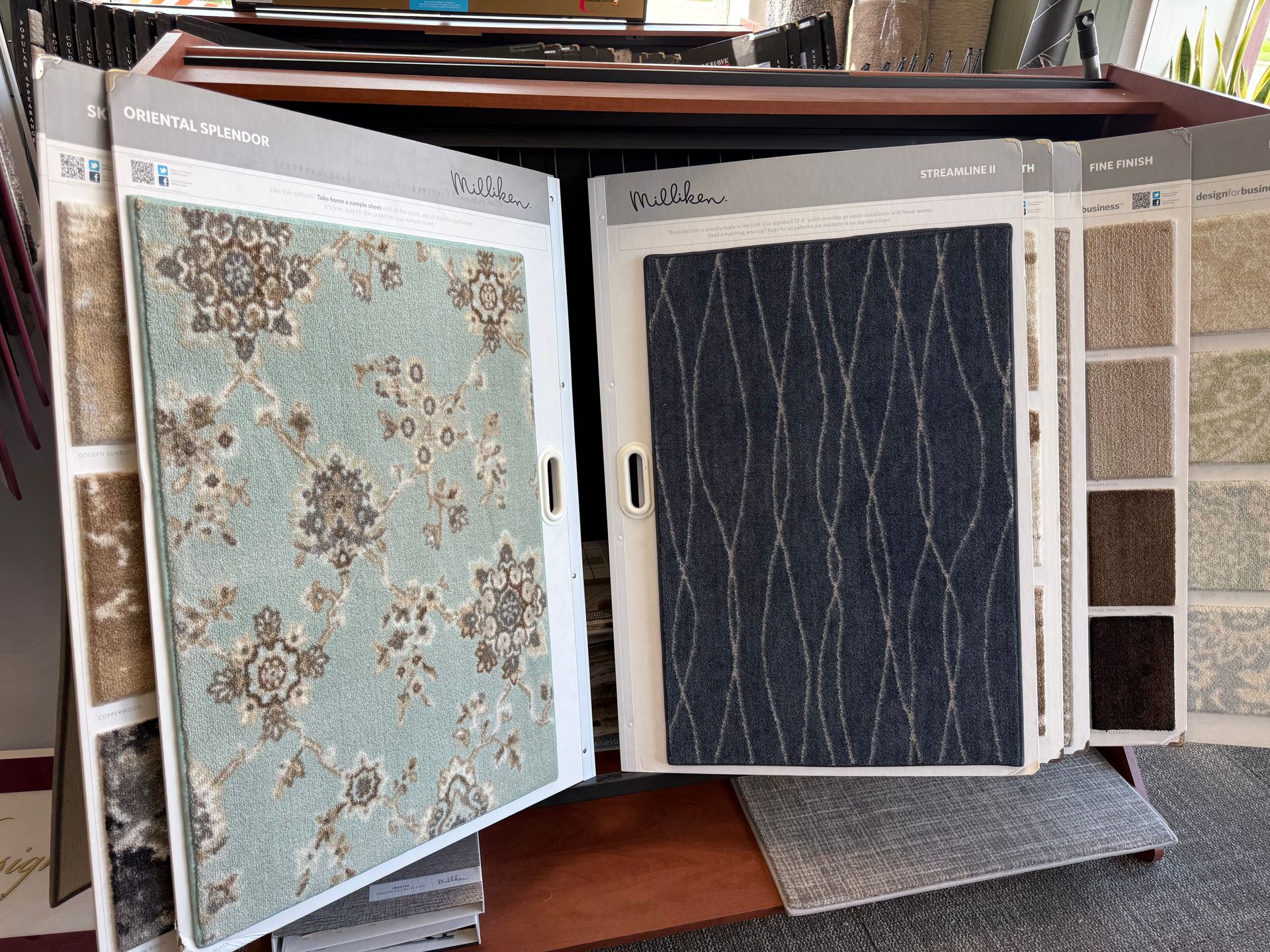 Open fabric sample book showing floral and dark blue patterned swatches on display