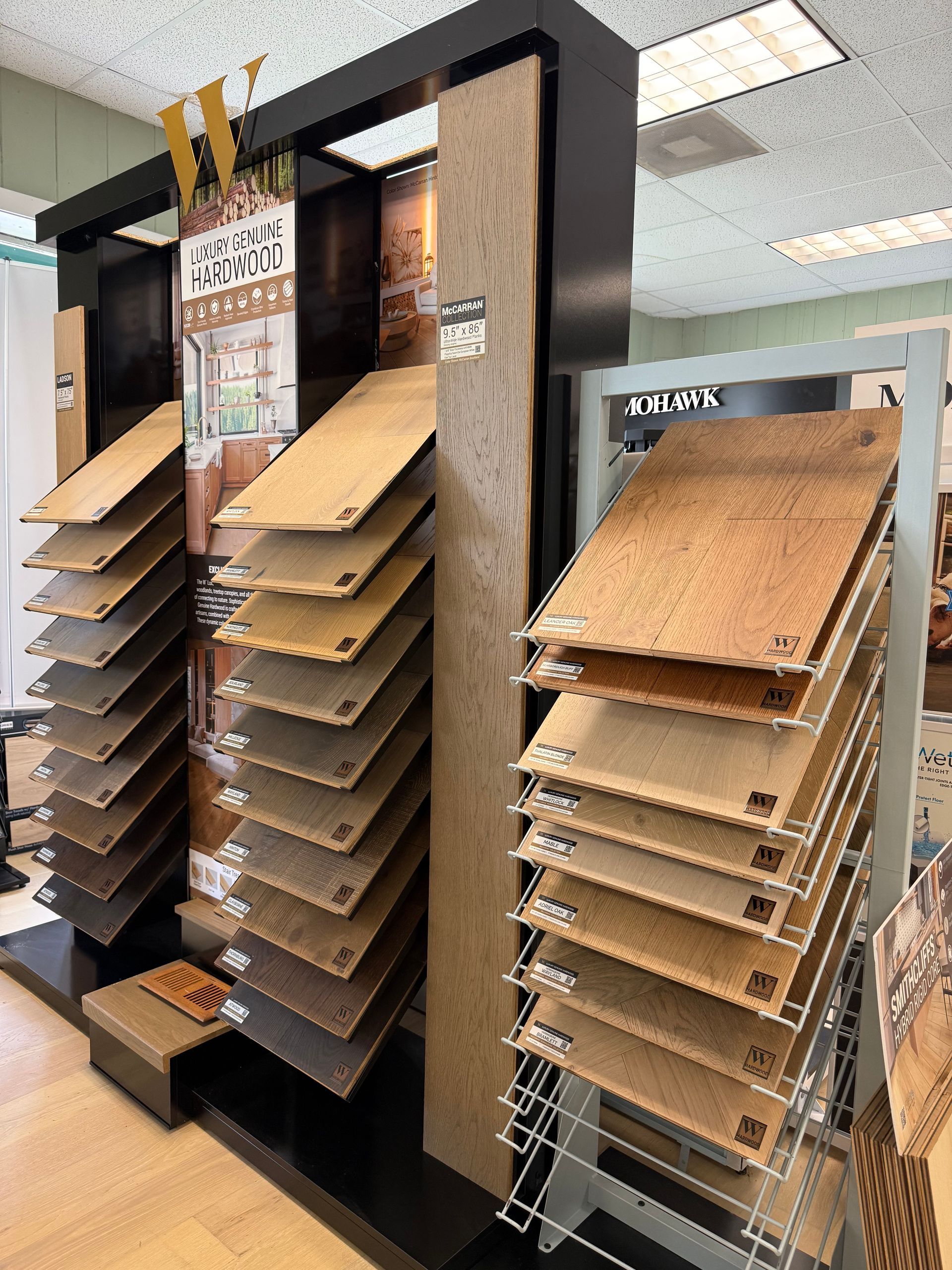 Store display of various wood sample boards on standing racks in a showroom.
