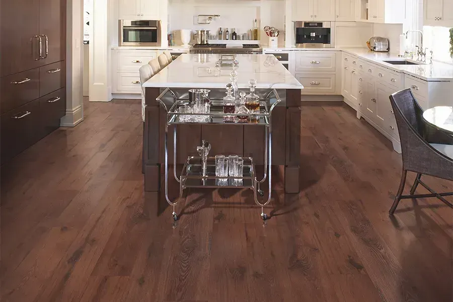 Modern kitchen with a dark wood floor, large island, and stainless steel appliances