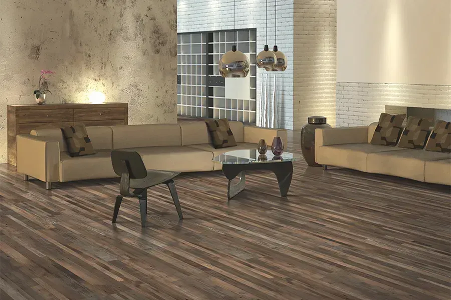 Modern living room with beige sofas, dark coffee table, and wood-look floor near a glass-block wall.