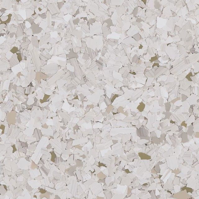 A textured surface featuring a speckled pattern of off-white, light gray, and muted green flakes.