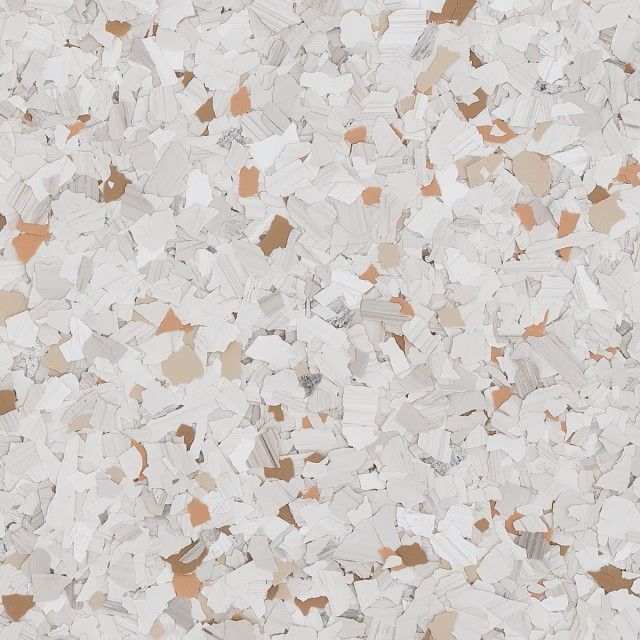 A textured pattern of multi-sized white, tan, and brown decorative vinyl flakes used for epoxy flooring.