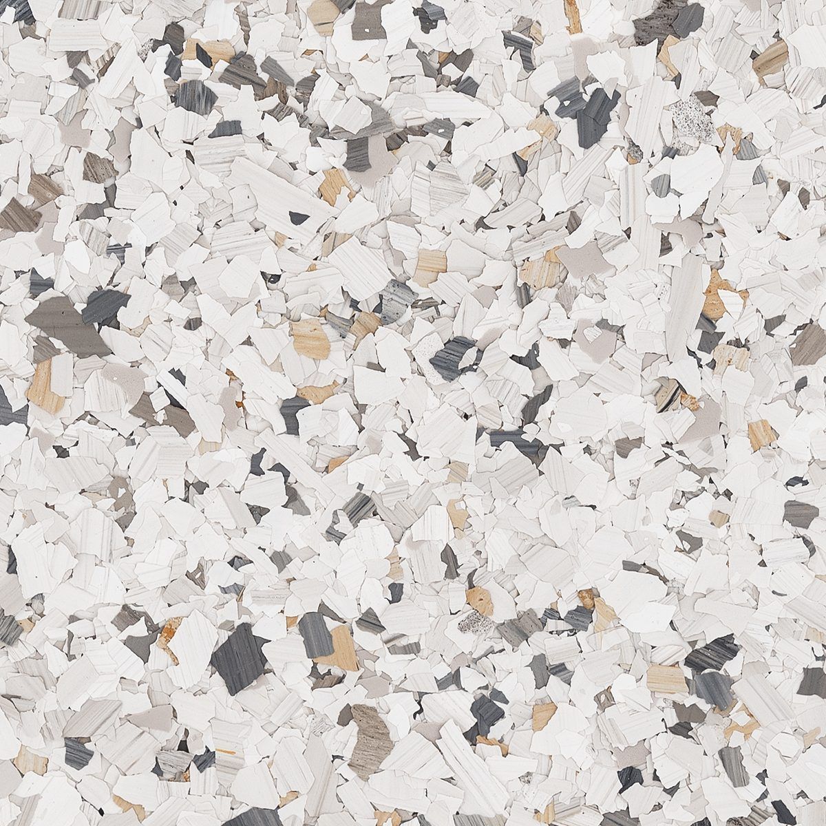 A close-up of decorative epoxy floor flakes in white, light gray, dark gray, and tan.