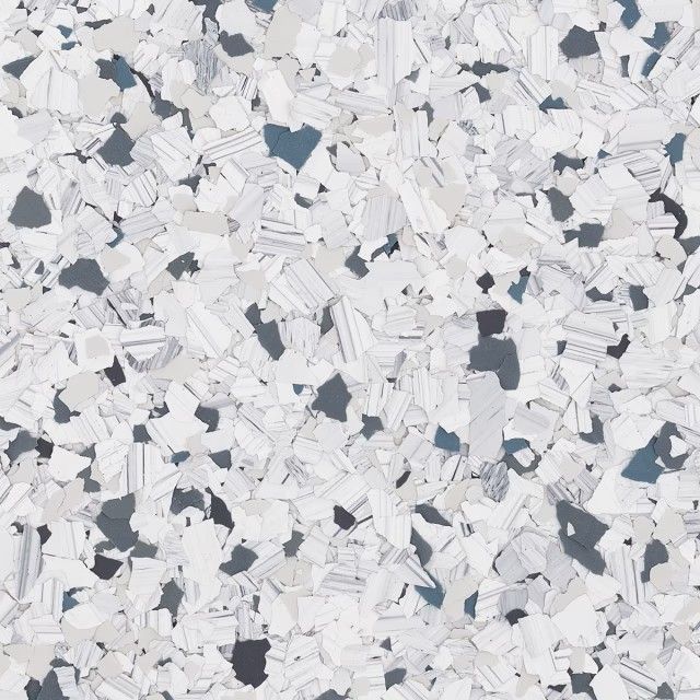 A textured surface pattern of small, scattered chips in shades of white, gray, and dark blue, resembling terrazzo flooring.