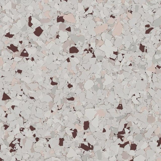 A close-up of a decorative epoxy floor finish featuring a light gray base with scattered brown, white, and tan flakes.