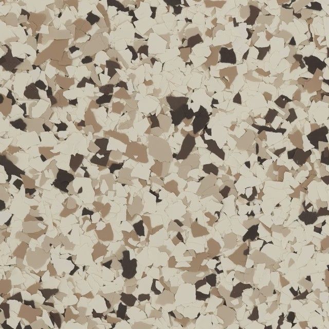 A high-angle view of a floor surface featuring a mix of cream, tan, and dark brown paint chips in an epoxy finish.