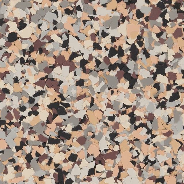 A decorative epoxy floor flake pattern featuring a mix of tan, beige, dark brown, grey, and black chips.