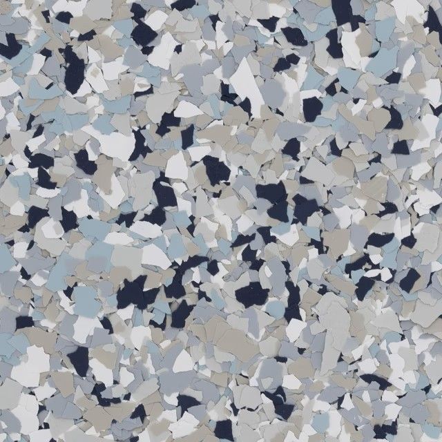 A close-up of a decorative epoxy floor finish featuring a multi-colored flake blend of navy, light blue, gray, and white.