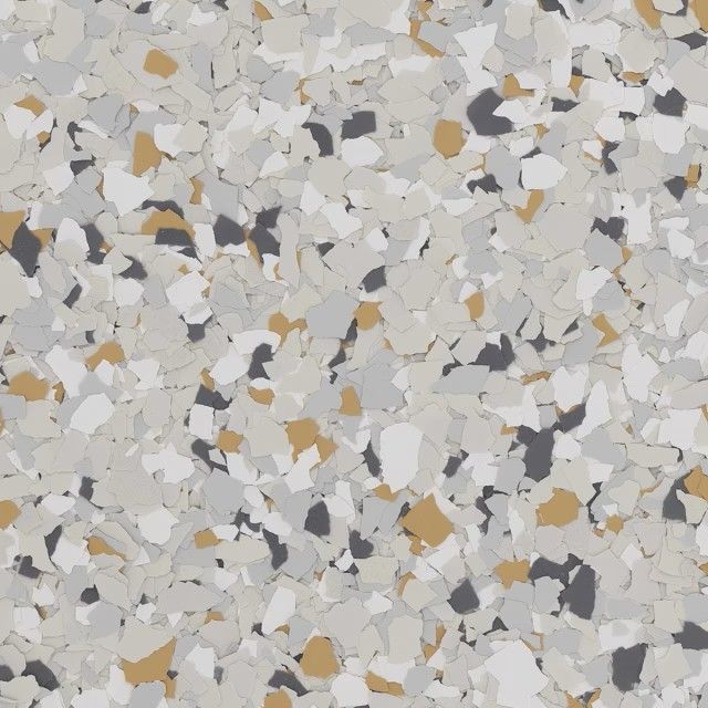 A close-up of decorative epoxy floor flakes in a mix of light grey, white, charcoal, and tan colors.