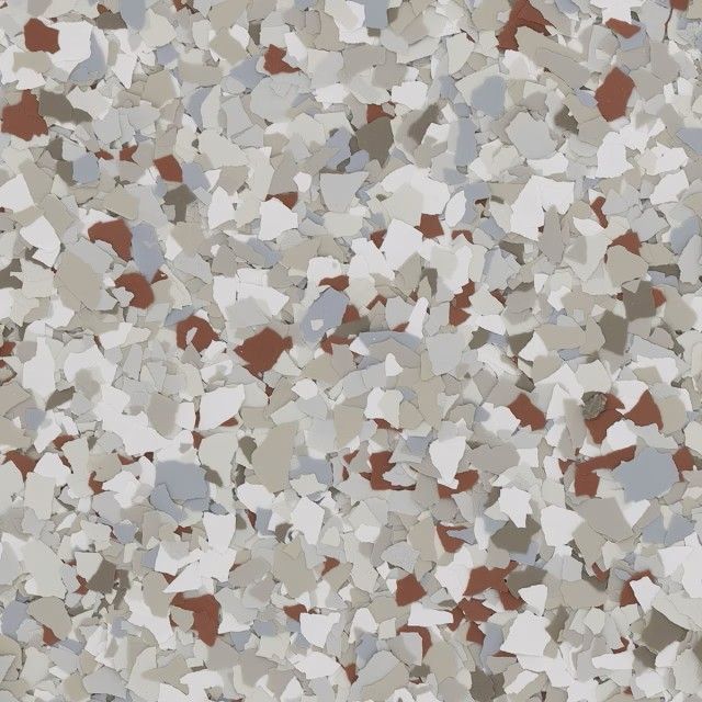 A close-up of decorative epoxy floor flakes in shades of white, gray, tan, and reddish-brown.