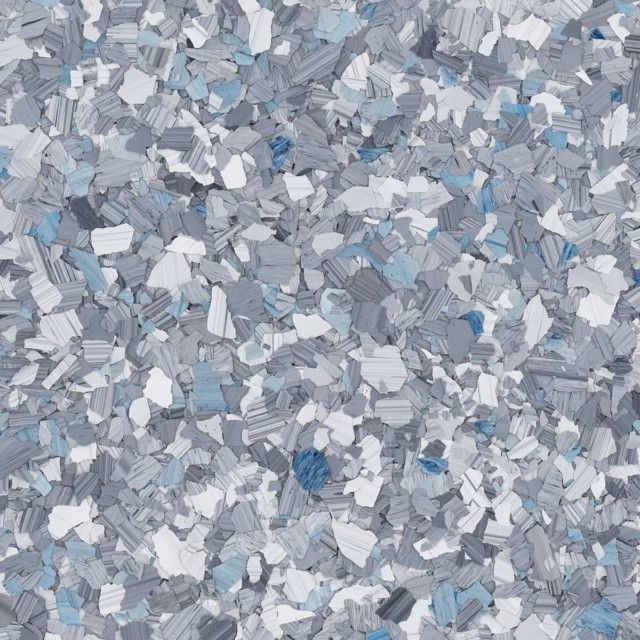 A close-up of decorative vinyl paint chips in shades of grey, white, and blue, often used for epoxy floor coatings.