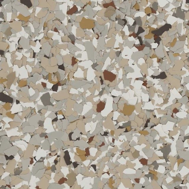 A close-up of decorative epoxy floor flakes in a blend of white, beige, grey, and brown earth tones.