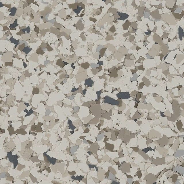 Close-up of a decorative epoxy flooring texture with a speckled pattern of tan, gray, cream, and dark charcoal flakes.